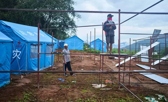 Workers weld metal frames while building temporary shelters for survivors of recent flash floods in Nepal's Nuwakot district, Wednesday, Sept. 23, 2026. (AP Photo/Niranjan Shrestha)