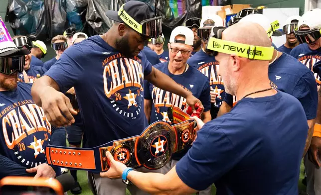Houston Astros manager Joe Espada, right, presents Yordan Alvarez with a championship belt after defeating the Athletics 9-0 to win the American League West after a baseball game at Sutter Health Park in West Sacramento, Calif., Sunday, Sept. 27, 2026. (Jason Fochtman/Houston Chronicle via AP)