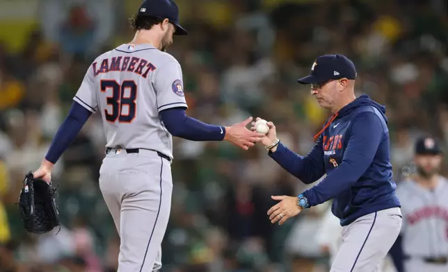Houston Astros pitcher Peter Lambert (38) hands the ball to manager Joe Espada, right, after being pulled during the third inning of a baseball game against the Athletics Thursday, Sept. 24, 2026, in West Sacramento, Calif. (AP Photo/Scott Marshall)