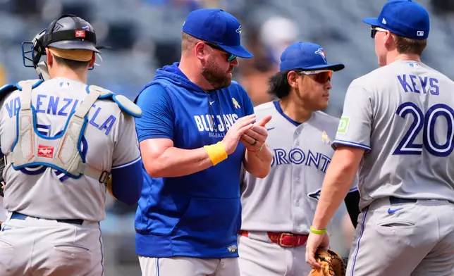 Toronto Blue Jays manager John Schneider stands with players on the mound during a pitching change in the fifth inning of a baseball game against the Kansas City Royals, Sunday, Sept. 6, 2026, in Kansas City, Mo. (AP Photo/Charlie Riedel)