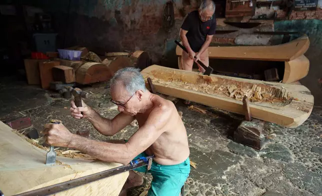 Traditional Chinese coffin maker Goh Khuay Par, left, and his brother Goh Khuay Hou, carve Mei Hua coffins at their workshop in Muar, Johor state, Malaysia, Wednesday, July. 29, 2026. (AP Photo/Vincent Thian)