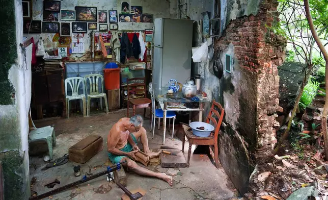 Traditional Chinese coffin maker Goh Khuay Par uses a hand tool to shape a miniature coffin at his workshop in Muar, Malaysia, Tuesday, July 14, 2026. (AP Photo/Vincent Thian)