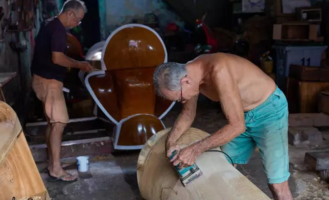 Traditional Chinese coffin maker Goh Khuay Par, right, carves a Mei Hua coffin as his brother Goh Khuay Hou paints another at their workshop in Muar, Johor state, Malaysia, Thursday, Sept. 3, 2026. (AP Photo/Vincent Thian)