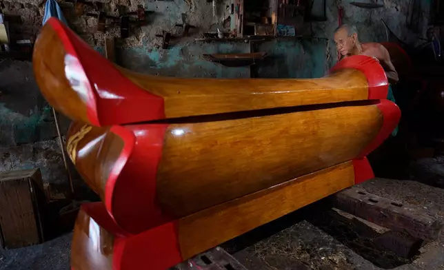 Goh Khuay Par inspects a completed Mei Hua coffin at his workshop in Muar, Malaysia, Monday, Sept. 7, 2026. (AP Photo/Vincent Thian)