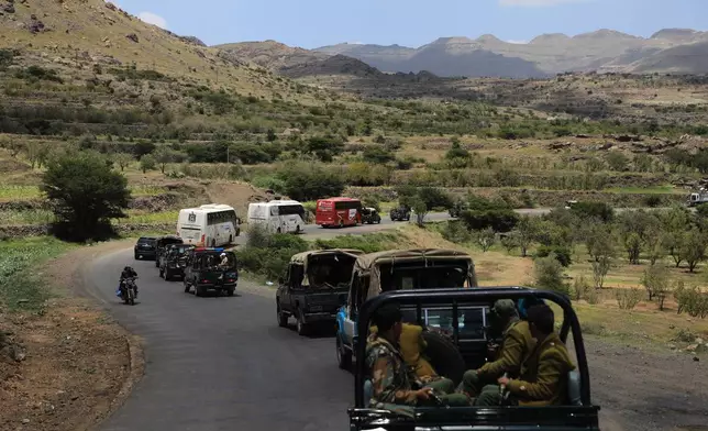 Houthi fighters escort a convoy carrying prisoners freed in Mokha through the Bani Matar district on its way to Sanaa, Yemen, Saturday, Sept. 12, 2026, following the Houthi takeover of the southern Red Sea port city. (AP Photo/STR)