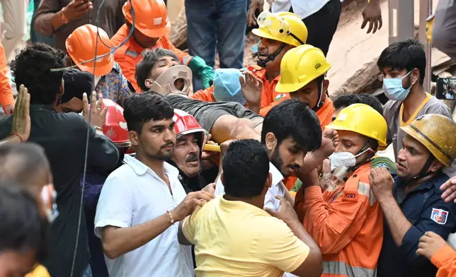 Rescue workers carry a student they have rescued from the debris of a collapsed building in New Delhi, India, Sunday, Sept. 6, 2026.(AP Photo/ Vipin)