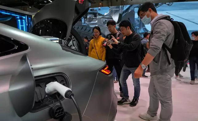 FILE - Visitors look at a Geely Galaxy E8 electric car during the Auto China 2024 in Beijing, Sunday, April 28, 2024. (AP Photo/Andy Wong, File)