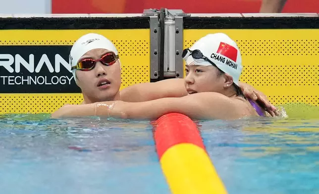 Yu Zidi of China, left, and Chang Mohan of China reach towards each other after competing in swimming at the Asian Games in Tokyo, Japan, Sunday, Sept. 20, 2026. (AP Photo/Hiro Komae)