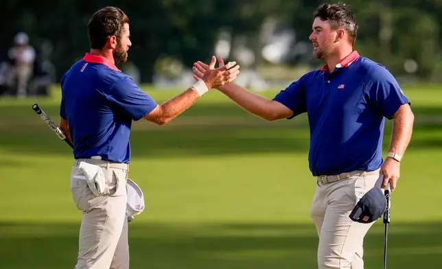 USA teams' Chris Gotterup, right, celebrates with Cameron Young after defeating the International team after their Presidents Cup golf tournament third round foursome match at Medinah Country Club, Saturday, Sept. 26, 2026, in Medinah, Ill. (AP Photo/Matt Slocum)
