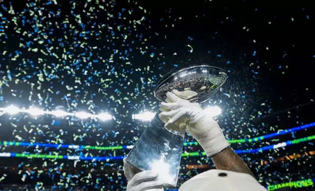 FILE - A member of the Seattle Seahawks celebrates with the Lombardi Trophy after defeating the New England Patriots in the NFL Super Bowl 60 football game, Feb. 8, 2026, in Santa Clara, Calif. (AP Photo/Brynn Anderson, File)