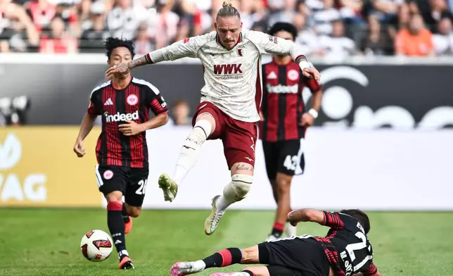 Augsburg's Marius Wolf, top, and Eintracht Frankfurt's Mario Götze battle for the ball during the German Bundesliga soccer match between Eintracht Frankfurt and FC Augsburg in Frankfurt, Germany, Sunday, Sept. 6, 2026. (Florian Wiegand/dpa via AP)
