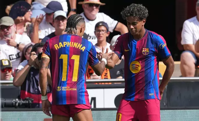 Barcelona's Lamine Yamal celebrates with teammate Raphinha after scoring the opening goal during the Spanish La Liga soccer match between Valencia and Barcelona in Valencia, Spain, Sunday, Sept. 6, 2026. (AP Photo/Alberto Saiz)