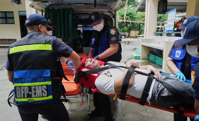 A mock victim is carried by medical personnel during a nationwide school safety drill in San Rafael, Bulacan province, Philippines, Thursday, Sept. 3, 2026. (AP Photo/Aaron Favila)
