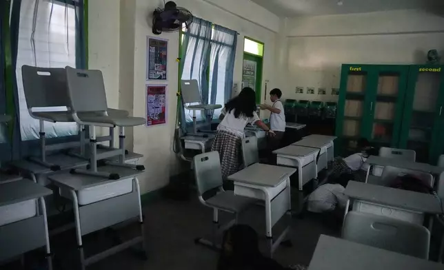 Students stack chairs to block windows during a nationwide school safety drill in San Rafael, Bulacan province, Philippines, Thursday, Sept. 3, 2026. (AP Photo/Aaron Favila)