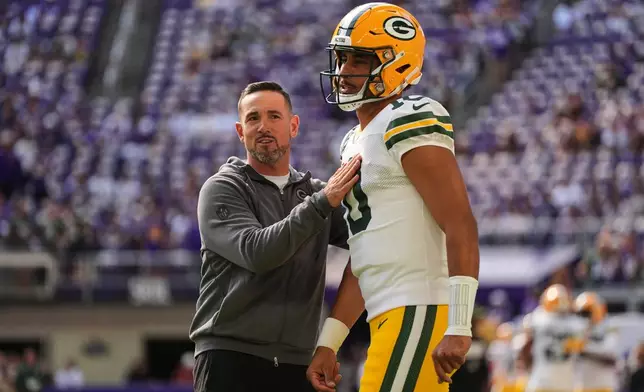 Green Bay Packers head coach Matt LaFleur, left, talks with quarterback Jordan Love, right, during warmups before an NFL football game against the Minnesota Vikings, Sunday, Sept. 13, 2026, in Minneapolis, Minn. (AP Photo/Abbie Parr)