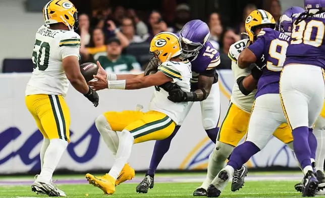 Green Bay Packers quarterback Jordan Love (10) fumbles the ball after being hit by Minnesota Vikings linebacker Dallas Turner (15) during the second half of an NFL football game, Sunday, Sept. 13, 2026, in Minneapolis, Minn. (AP Photo/Abbie Parr)