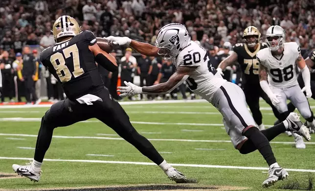 New Orleans Saints tight end Noah Fant (87) catches a touchdown pass as Las Vegas Raiders safety Isaiah Pola-Mao (20) defends during the first half of an NFL football game in New Orleans, Sunday, Sept. 27, 2026. (AP Photo/Gerald Herbert)