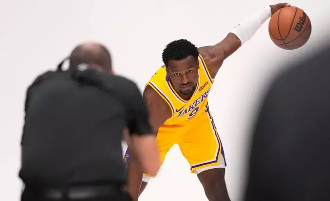 Los Angeles Lakers guard Bronny James poses for pictures with NBA photographer Adam Pantozzi during media day Monday, Sept. 28, 2026, in El Segundo, Calif. (AP Photo/Mark J. Terrill)