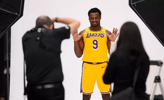 Los Angeles Lakers guard Bronny James poses for pictures with NBA photographer Adam Pantozzi during media day Monday, Sept. 28, 2026, in El Segundo, Calif. (AP Photo/Mark J. Terrill)