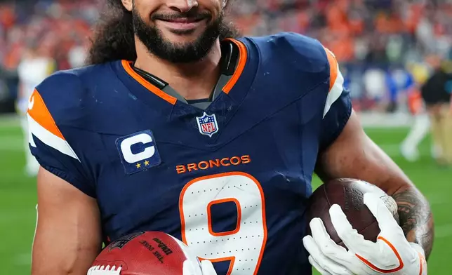 Denver Broncos safety Talanoa Hufanga holds footballs following an NFL football game against the Los Angeles Rams, Sunday, Sept. 27, 2026, in Denver. (AP Photo/Jack Dempsey)