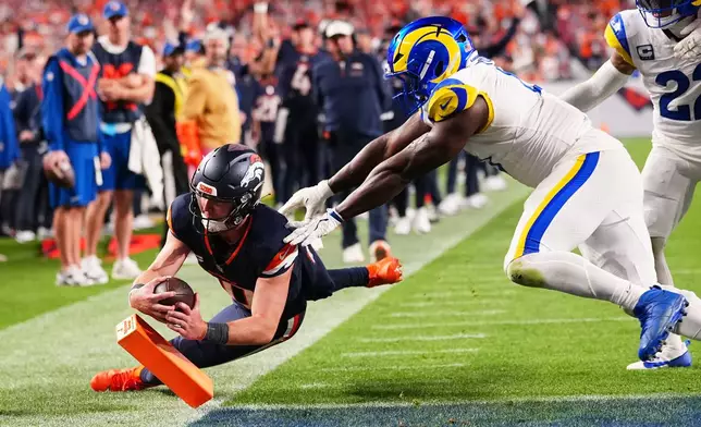 Denver Broncos quarterback Bo Nix, left, steps out of bound while trying to score a touchdown as Los Angeles Rams linebacker Byron Young pushes him out of bounds during the second half of an NFL football game Sunday, Sept. 27, 2026, in Denver. (AP Photo/Jack Dempsey)