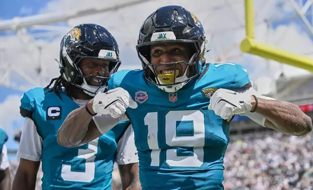 Jacksonville Jaguars wide receiver Josh Cameron (19) celebrates his touchdown pass with wide receiver Jakobi Meyers (3) in the first half of an NFL football game against the Cleveland Browns, Sunday, Sept. 13, 2026, in Jacksonville. (AP Photo/Phelan M. Ebenhack)