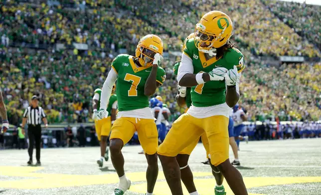 Oregon wide receivers Evan Stewart (7) and Dakorien Moore (1) celebrate Moore's touchdown during the second half of an NCAA college football game, Saturday, Sept. 5, 2026, in Eugene, Ore. (AP Photo/Lydia Ely)