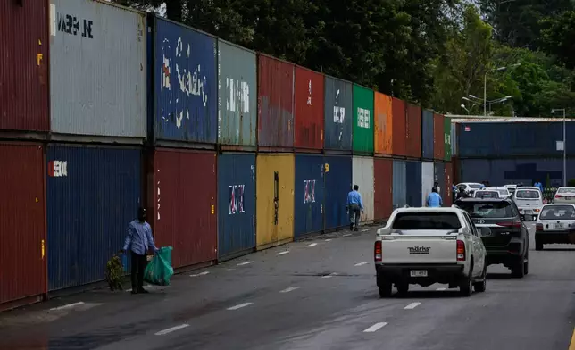Vehicles drive past shipping containers placed by authorities to seal off an area ahead of a plan protest march by the supporters of imprisoned former Prime Minister Imran Khan demanding his release, in Islamabad, Pakistan, Monday, Sept. 28, 2026. (AP Photo/Anjum Naveed)