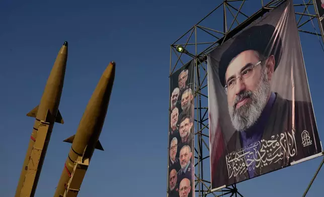 Iranian missiles and banners showing portraits of the Iranian Supreme Leader Ayatollah Mojtaba Khamenei, right, and the late armed forces commanders, who were killed in Israeli and U.S. strikes, are displayed in a military exhibition commemorating the anniversary of the start of the 1980-88 Iraq-Iran war at Baharestan Square, in Tehran, Monday, Sept. 28, 2026. (AP Photo/Vahid Salemi)