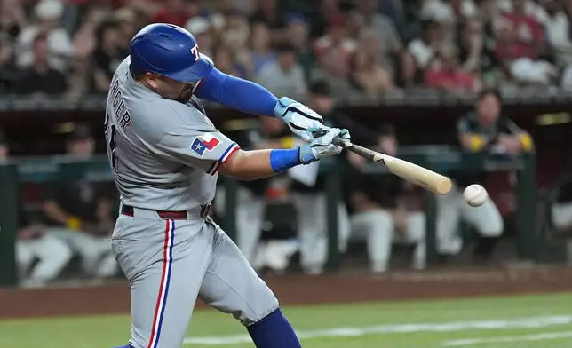 Texas Rangers' Jake Burger connects for a single against the Arizona Diamondbacks during the fifth inning of a baseball game, Saturday, Sept. 12, 2026, in Phoenix. (AP Photo/Ross D. Franklin)