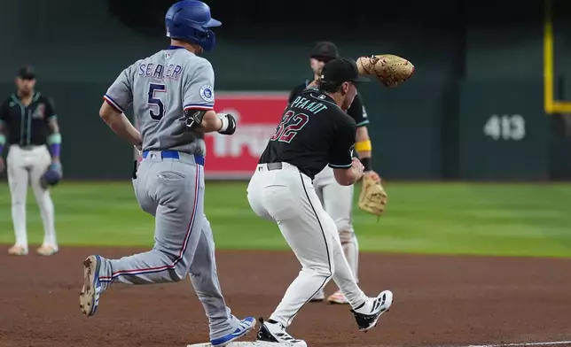Texas Rangers'Corey Seager (5) reaches first base safely as Arizona Diamondbacks starting pitcher Brandon Pfaadt (32) has his foot off the base during the fifth inning of a baseball game, Saturday, Sept. 12, 2026, in Phoenix. (AP Photo/Ross D. Franklin)