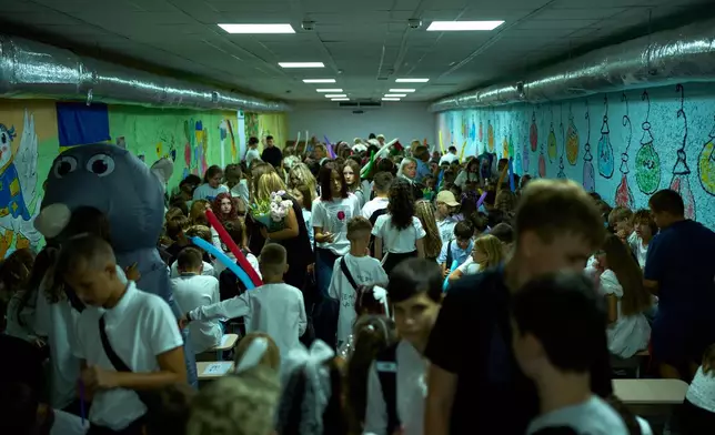 Children, parents and teachers stay in an underground shelter during an air raid alarm during the traditional back to school celebrations in Kyiv, Tuesday, Sept. 1, 2026. (AP Photo/Francisco Seco)