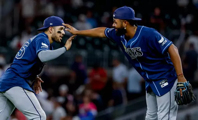 Tampa Bay Rays right fielder Victor Mesa Jr., left, celebrates with third baseman Junior Caminero, right, after defeating the Atlanta Braves during the ninth inning of a baseball game, Wednesday, Sept. 9, 2026, in Atlanta. (AP Photo/Erik S. Lesser)