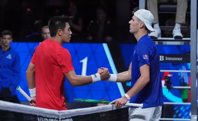 Team World's Brandon Nakashima, left, shakes hands with Team Europe's Jakub Mensik after winning a Laver Cup tennis tournament match in London, Friday, Sept. 25, 2026. (AP Photo/Maja Smiejkowska)