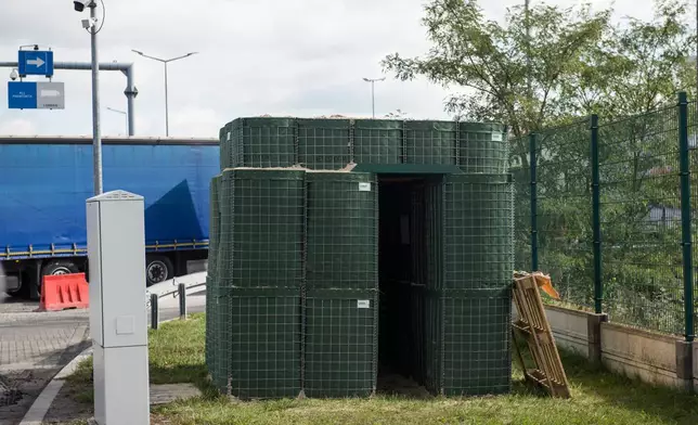 A bunker built of sandbags, which serves as shelter for border guards, stands next to the lanes at the Dorohusk-Jagodzin border crossing between Poland and Ukraine, in Dorohusk, Poland, on Sept. 24, 2026. (AP Photo/Attila Husejnow)