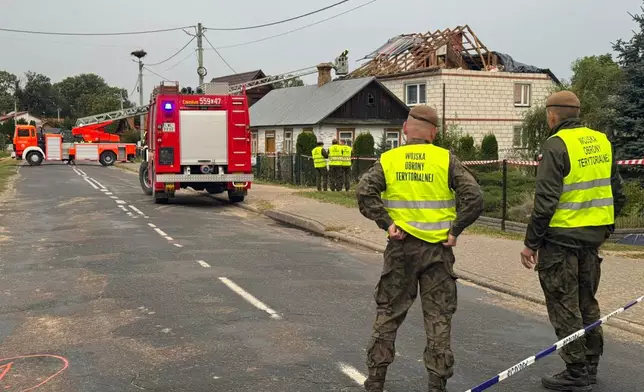 FILE - Firefighters and territorial defence officers stand close to the destroyed roof of a house, after Russian drones violated Polish airspace during an attack on Ukraine, in Wyryki near Lublin, Poland, Sept. 11, 2025. (AP Photo/Rafal Niedzielski, File)