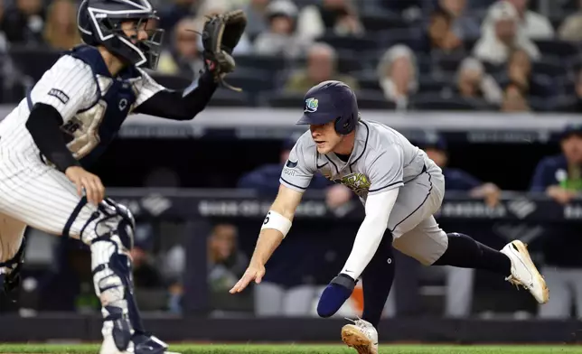 Tampa Bay Rays' Taylor Walls scores a run past New York Yankees catcher Austin Wells in the seventh inning during the second baseball game of a doubleheader Tuesday, Sept. 22, 2026, in New York. (AP Photo/Adam Hunger)