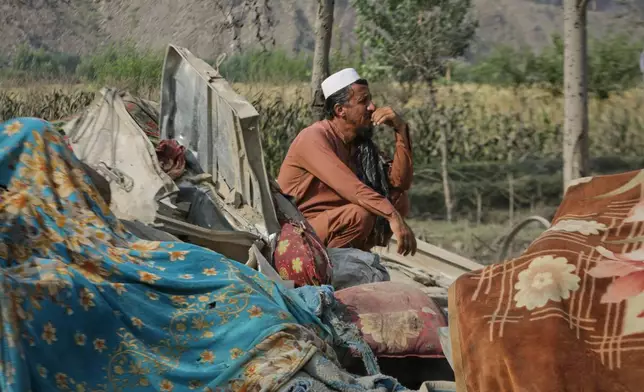 A man sits amid household belongings and the wreckage of a house destroyed in a strike in Patan village, Kunar province, eastern Afghanistan, Monday, Sept. 21, 2026. (AP Photo/Shafiullah Kakar)
