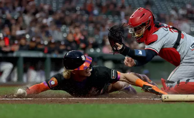 San Francisco Giants' Jonah Cox, left, is tagged out at home by Minnesota Twins catcher Victor Caratini, right, on a fielder's choice hit by Victor Bericoto during the first inning of a baseball game in San Francisco, Tuesday, Sept. 22, 2026. (AP Photo/Jed Jacobsohn)