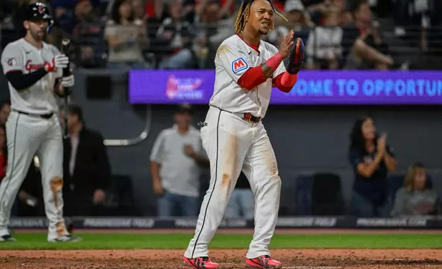 Cleveland Guardians' Jose Ramirez, center, reacts after scoring on a single hit by Angel Martinez during the sixth inning of a baseball game against the Athletics, Saturday, Sept. 19, 2026, in Cleveland. (AP Photo/Phil Long)