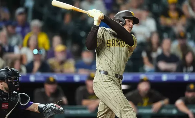 San Diego Padres' Dustin Harris connects for an RBI double off Colorado Rockies relief pitcher Juan Mejia in the eighth inning of a baseball game Monday, Sept. 14, 2026, in Denver. (AP Photo/David Zalubowski)