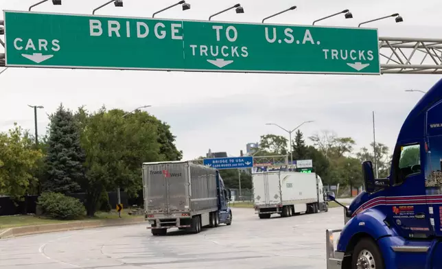 Transport trucks cross the Ambassador Bridge into the United States of America, in Windsor, Ontario, Canada, Saturday, Aug. 22, 2026. (Dax Melmer/The Canadian Press via AP)