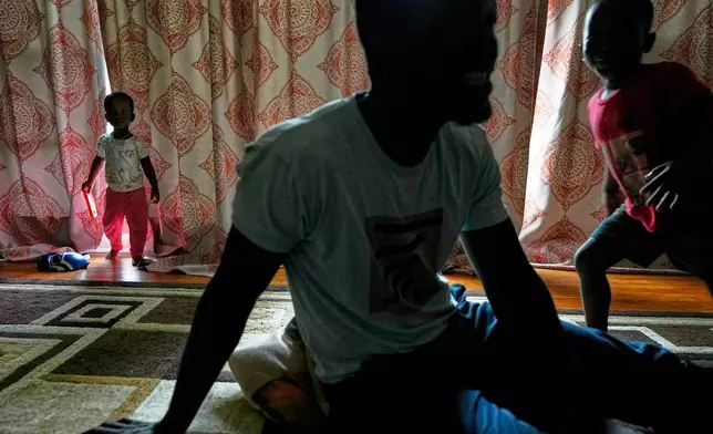 Khalidou Sy, a Mauritanian immigrant, sits with his children in the family's home in Lockland, Ohio, Friday, July 31, 2026. Sy, a well-known hip-hop artist back home, had been jailed for his music critical of the country's repressive government. (AP Photo/Carolyn Kaster)