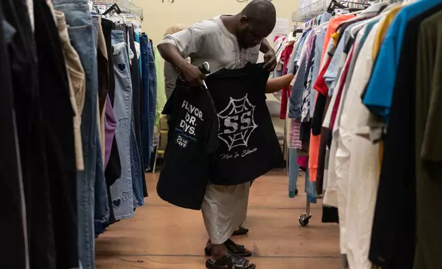 Mauritanian client Allasan Darko looks through donated clothing at Valley Interfaith Community Resource Center in Lockland, Ohio, Friday, July 10, 2026. (AP Photo/Carolyn Kaster)