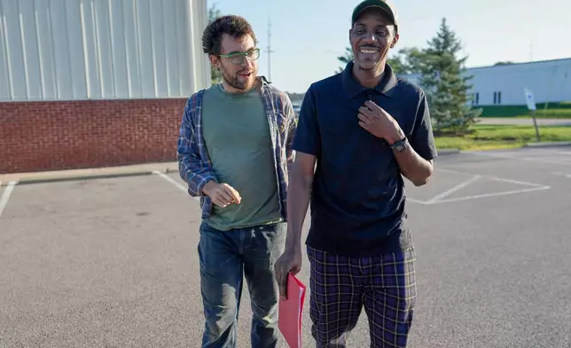 Vincent Wilson, left, walks with Samba Diallo, a Mauritanian immigrant back to Diallo's car after his regular appointment at an Immigration and Customs Enforcement office in Cincinnati, Monday, Sept. 14, 2026. (AP Photo/Carolyn Kaster)