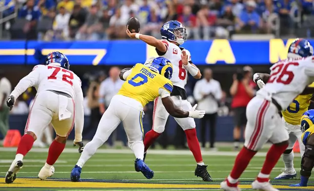 New York Giants quarterback Jaxson Dart (6) throws under pressure from Los Angeles Rams linebacker Byron Young during the first half of an NFL football game in Inglewood, Calif., Monday, Sept. 21, 2026. (AP Photo/Katie Chin)
