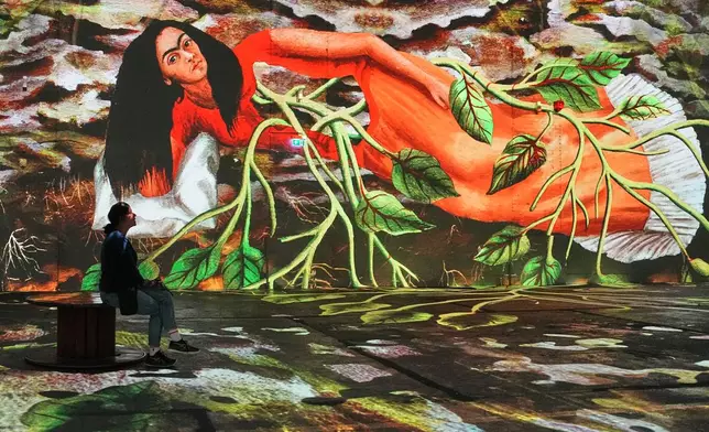 Visitors view an immersive digital art exhibition featuring 360-degree projections of works by Mexican artist Frida Kahlo at the Phoenix des Lumieres, an art center housed in a former puddling and rolling mill in Dortmund, Germany, Wednesday, Sept. 23, 2026. (AP Photo/Martin Meissner)