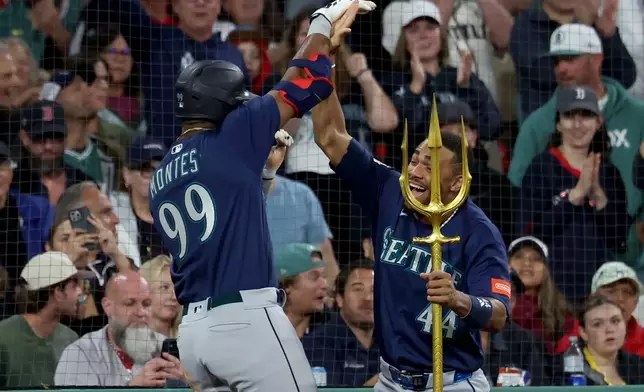 Seattle Mariners designated hitter Lazaro Montes (99) and outfielder Julio Rodríguez (44) celebrate Montes' home run during the fifth inning of a baseball game against the Boston Red Sox, Tuesday, Sept. 1, 2026, in Boston. (AP Photo/Mark Stockwell)