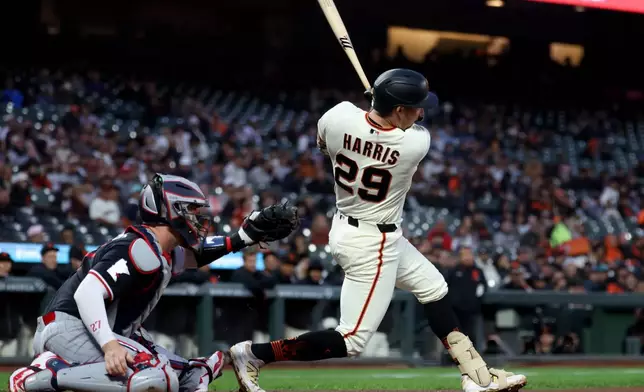 San Francisco Giants' Brett Harris (29) watches his two-run single in front of Minnesota Twins catcher Ryan Jeffers, left, during the first inning of a baseball game in San Francisco, Monday, Sept. 21, 2026. (AP Photo/Jed Jacobsohn)