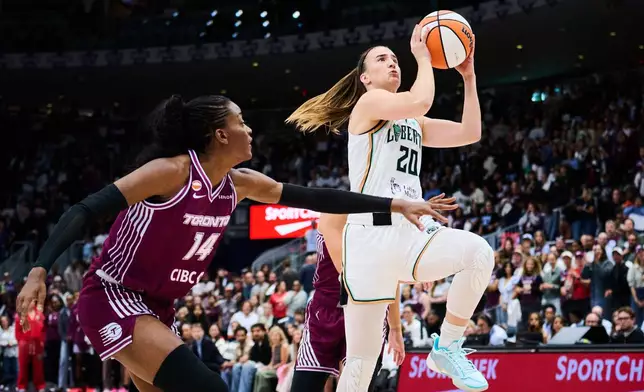 New York Liberty's Sabrina Ionescu (20) drives to the net past Toronto Tempo's Temi Fagbenle (14) during the first half of a WNBA basketball game in Toronto, Sunday, Sept. 20, 2026. (Sammy Kogan/The Canadian Press via AP)